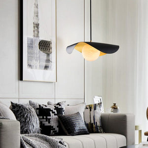 Modern living room with a stylish lamp, sofa, and wall art.
