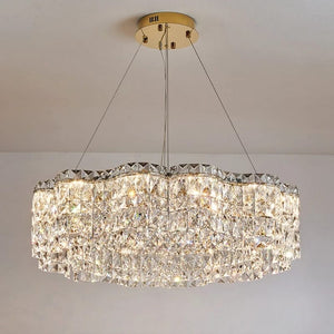 Crystal chandelier hanging from the ceiling against a plain background