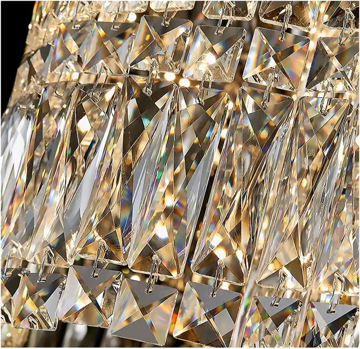 Close-up of a faceted crystal chandelier detail with multiple clear geometric prisms reflecting warm light and showing iridescent rainbow reflections.