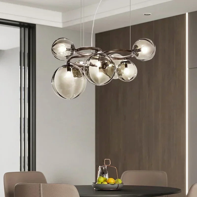 Modern chandelier hanging above a dining table with fruit bowl in a room.