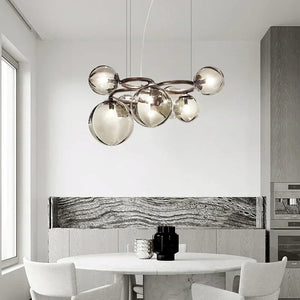 Modern kitchen with a stylish chandelier, marble backsplash, and white dining table.