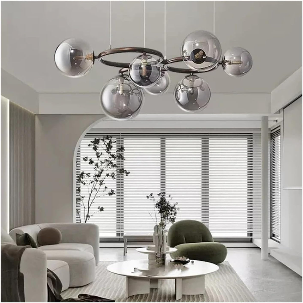 Modern multi-light chandelier with seven reflective silver glass globes on a dark metal frame, hanging in a contemporary minimalist living room.