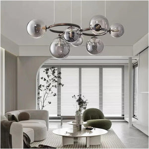 Modern multi-light chandelier with seven reflective silver glass globes on a dark metal frame, hanging in a contemporary minimalist living room.