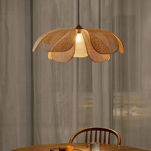 Woven pendant light hanging above a dining table with a blurred background