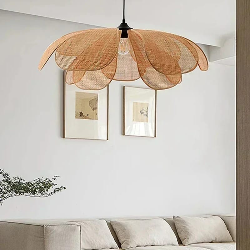 A flower-shaped pendant light with a woven wicker shade hangs above a sofa in a modern living room setting.