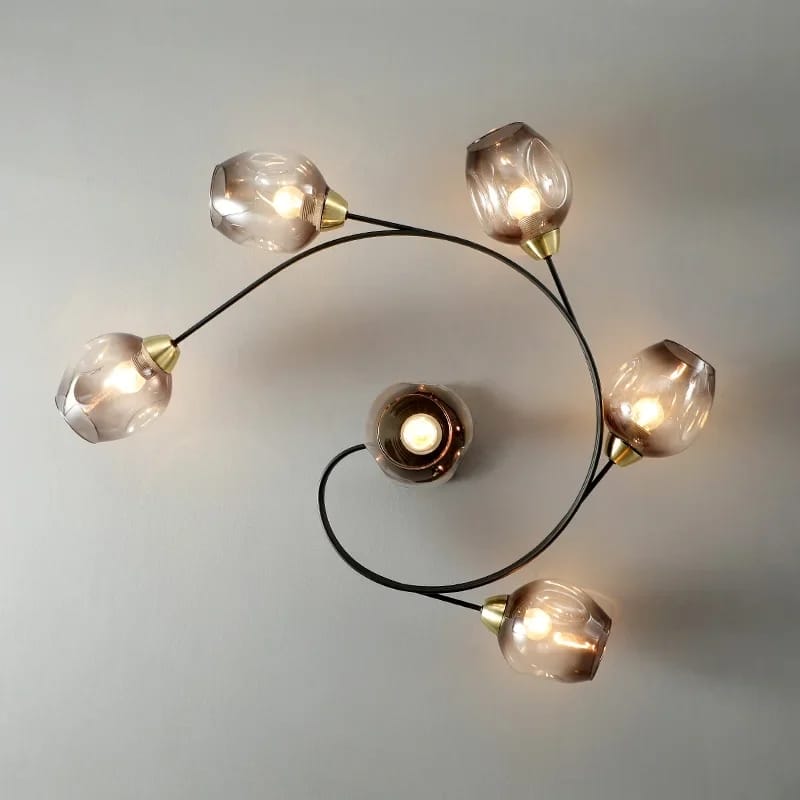 Modern ceiling light fixture with glass shades on a neutral background