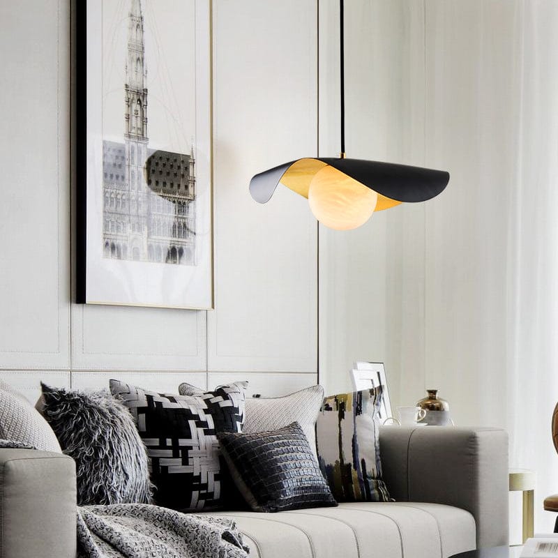 Modern living room with a stylish lamp, sofa, and wall art.