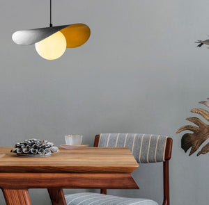 Modern dining room with wooden table, chair, and pendant light fixture.