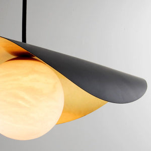 Modern pendant light with black and gold design on a gray background