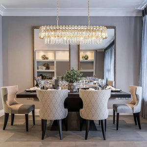 Dining room with a large chandelier, table set for dinner, and decorative elements.