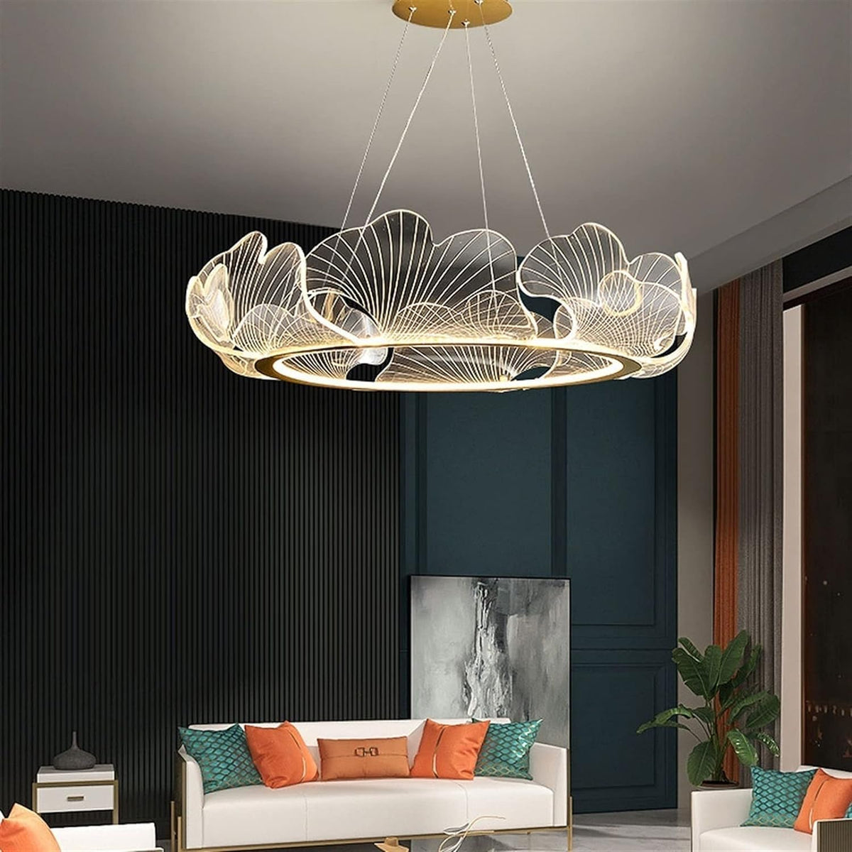 A modern circular pendant chandelier with a gold-toned metal frame and intricate wire filigree leaf-like designs, suspended in a contemporary living room setting.