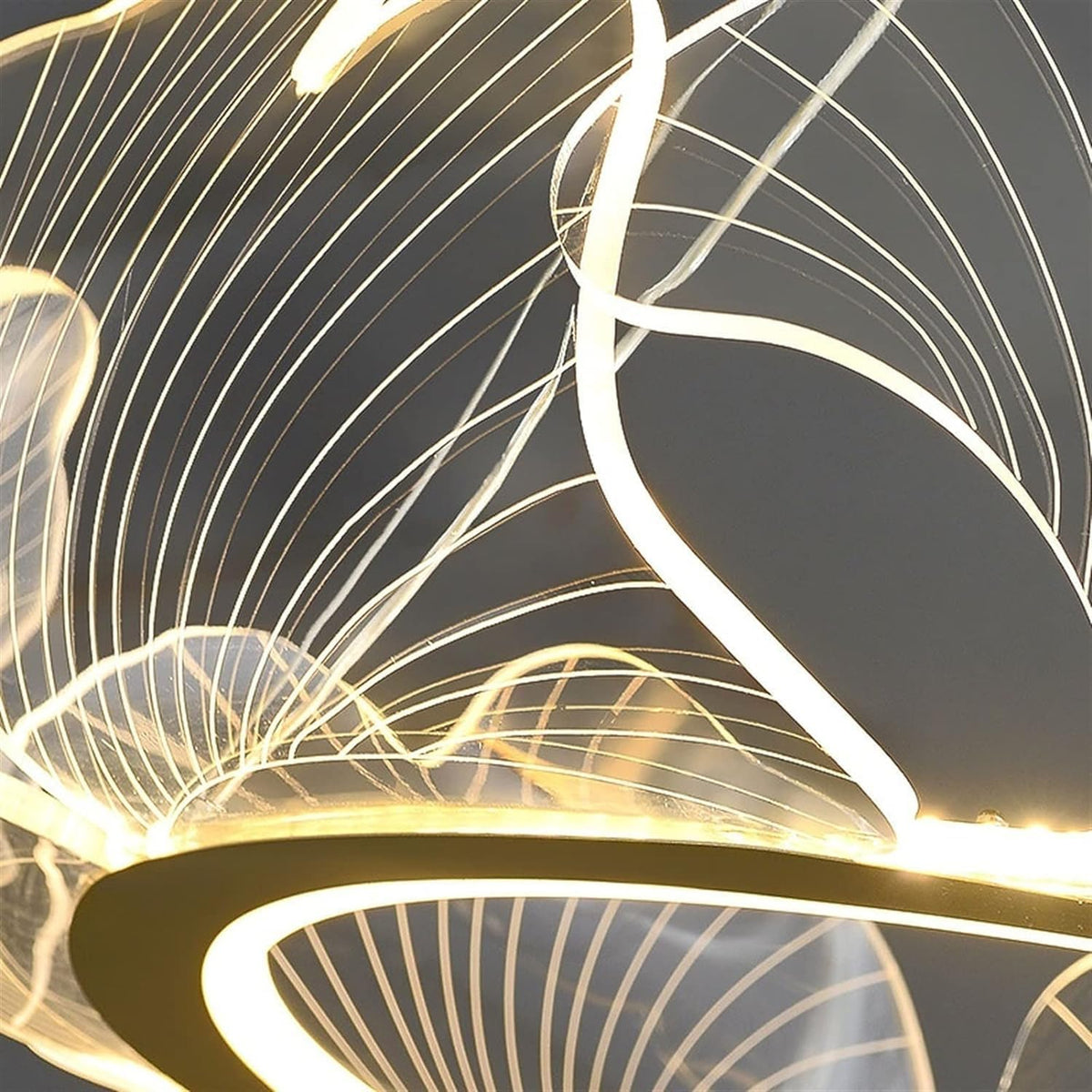 A close-up of a modern chandelier with glowing warm white LED light tubes and a gold-toned metal frame, set against a dark background.
